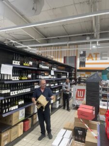 Travailleurs dans un supermarché avec des bouteilles de vin