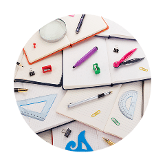 Fournitures scolaires sur des carnets ouverts.