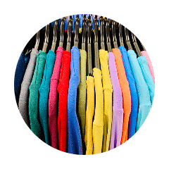 Vêtements colorés suspendus sur des cintres.